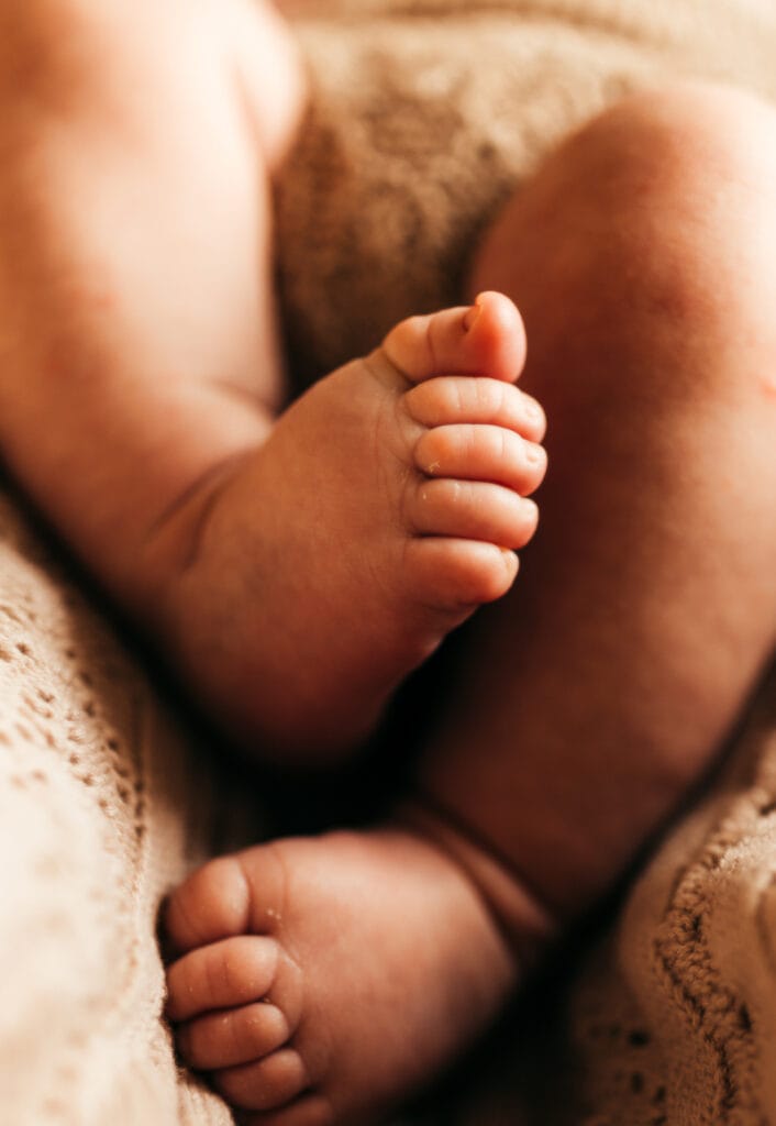 Newborn photographer, a baby's legs curl together
